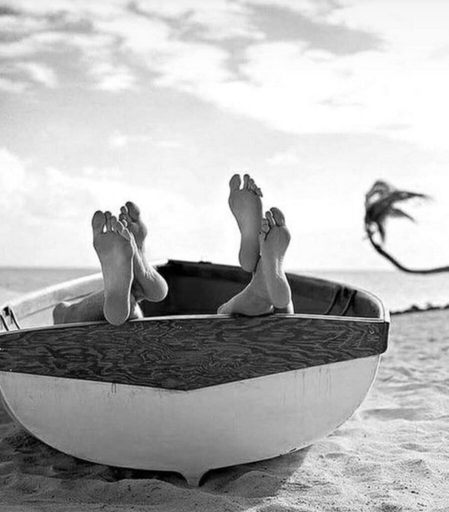 uomo e donna sulla barca che si baciano nascosti, si vestono solo i piedi. Jim Liam Scott