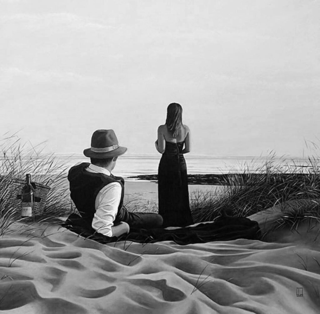 Uomo e donna sulla spiaggia, lui distesoche guarda lei.  lei in piedi che guarda il mare